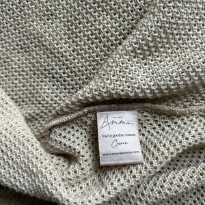 Amma nursing cover poncho, in a neutral cream/tan color.